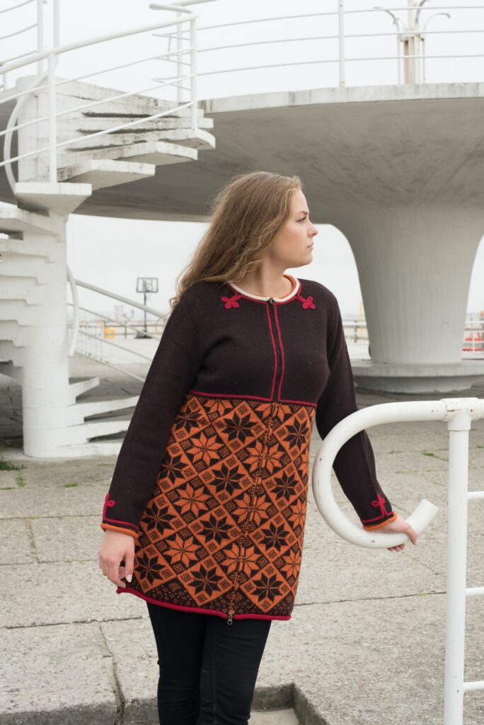 a blonde model on pärnu beach wearing Muhu patterned wool cardigan
