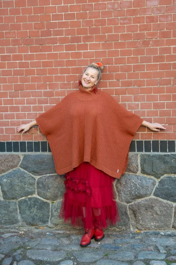 Poncho with fine cable pattern and protective symbol on chest