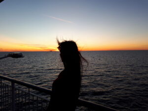 fashion designer kauni looking at the sunset from a boat on the sea